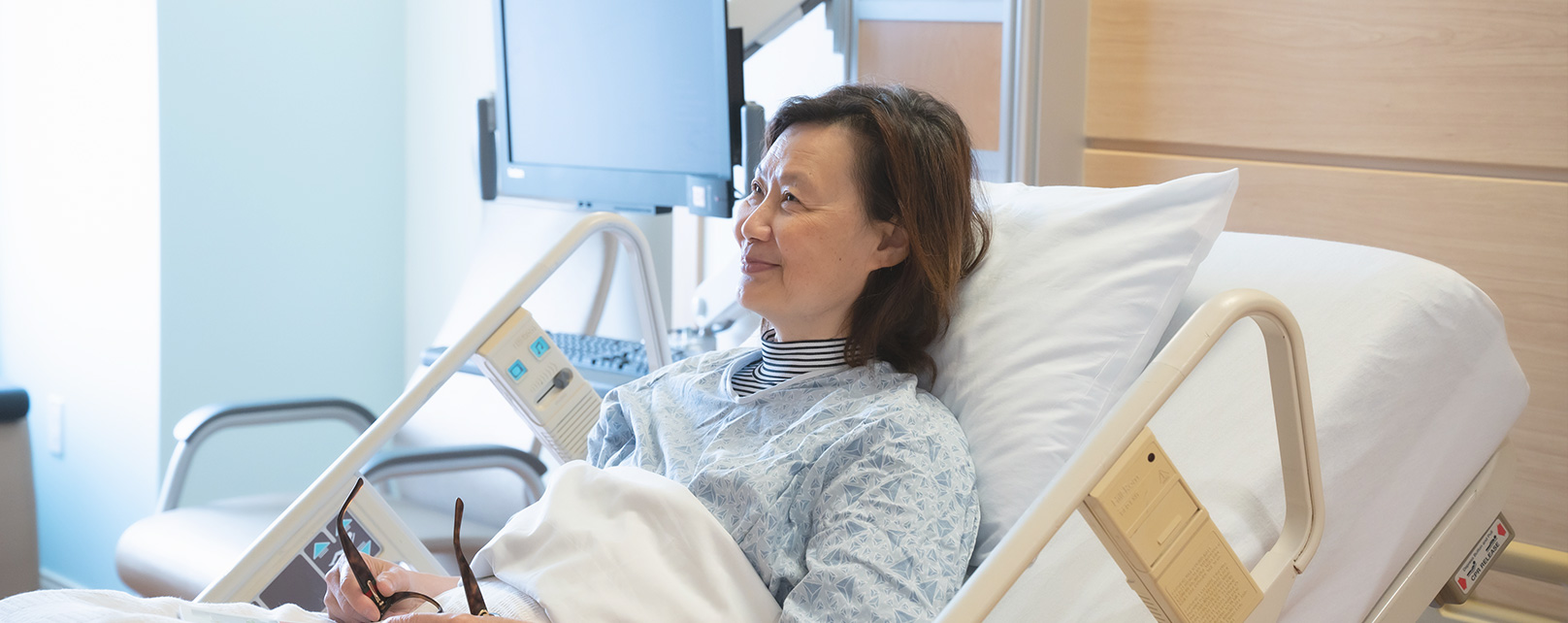 smiling patient lying in her hospital bed