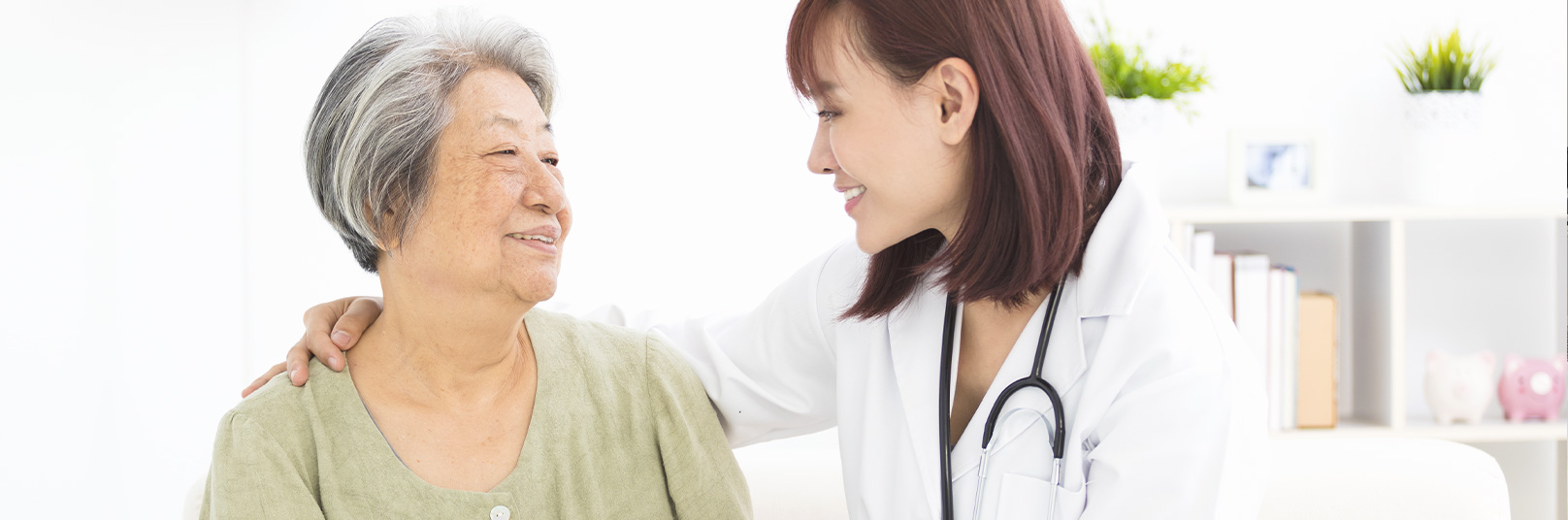 female doctor smiling with her arm around a smiling female patient