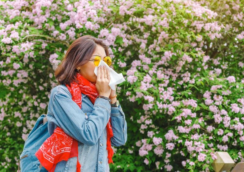 a woman blowing her nose in a tissue