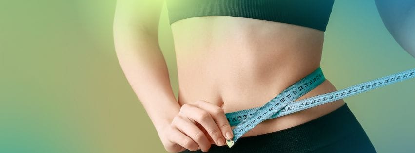 a woman measuring her waist