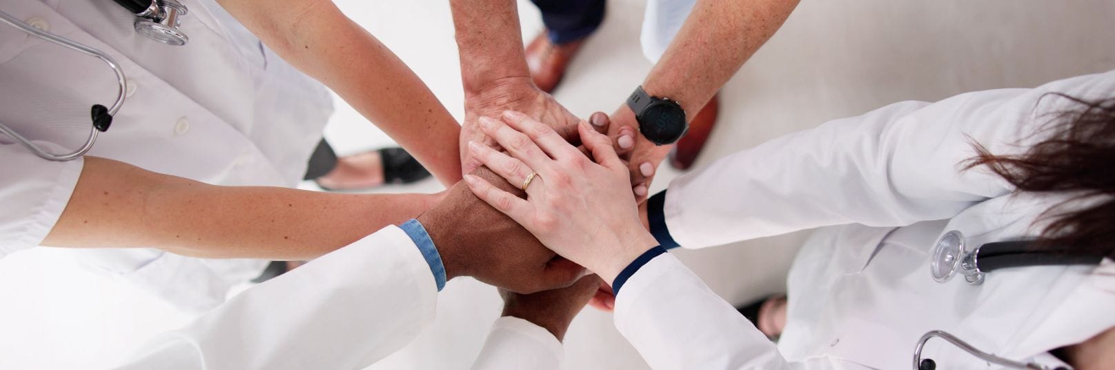 a group of people putting their hands together