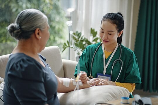 Nurse administering IV therapy at home.