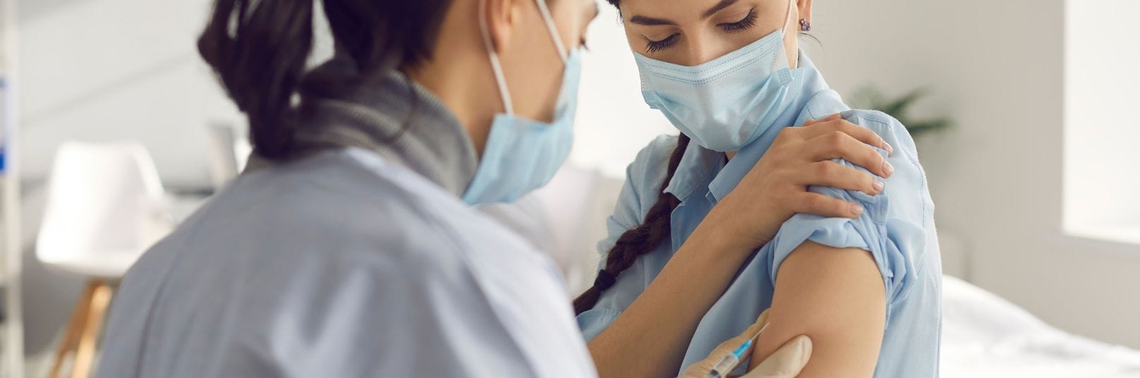 a woman in a mask holding a syringe